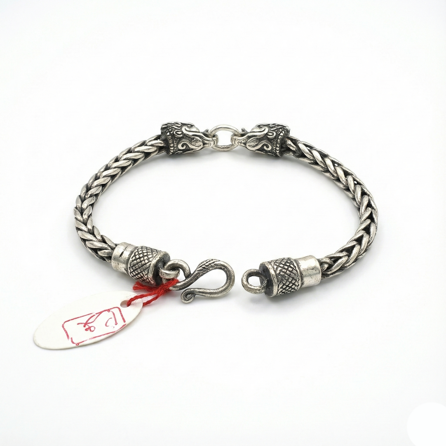 Silver braided bracelet with intricate designs on a white background