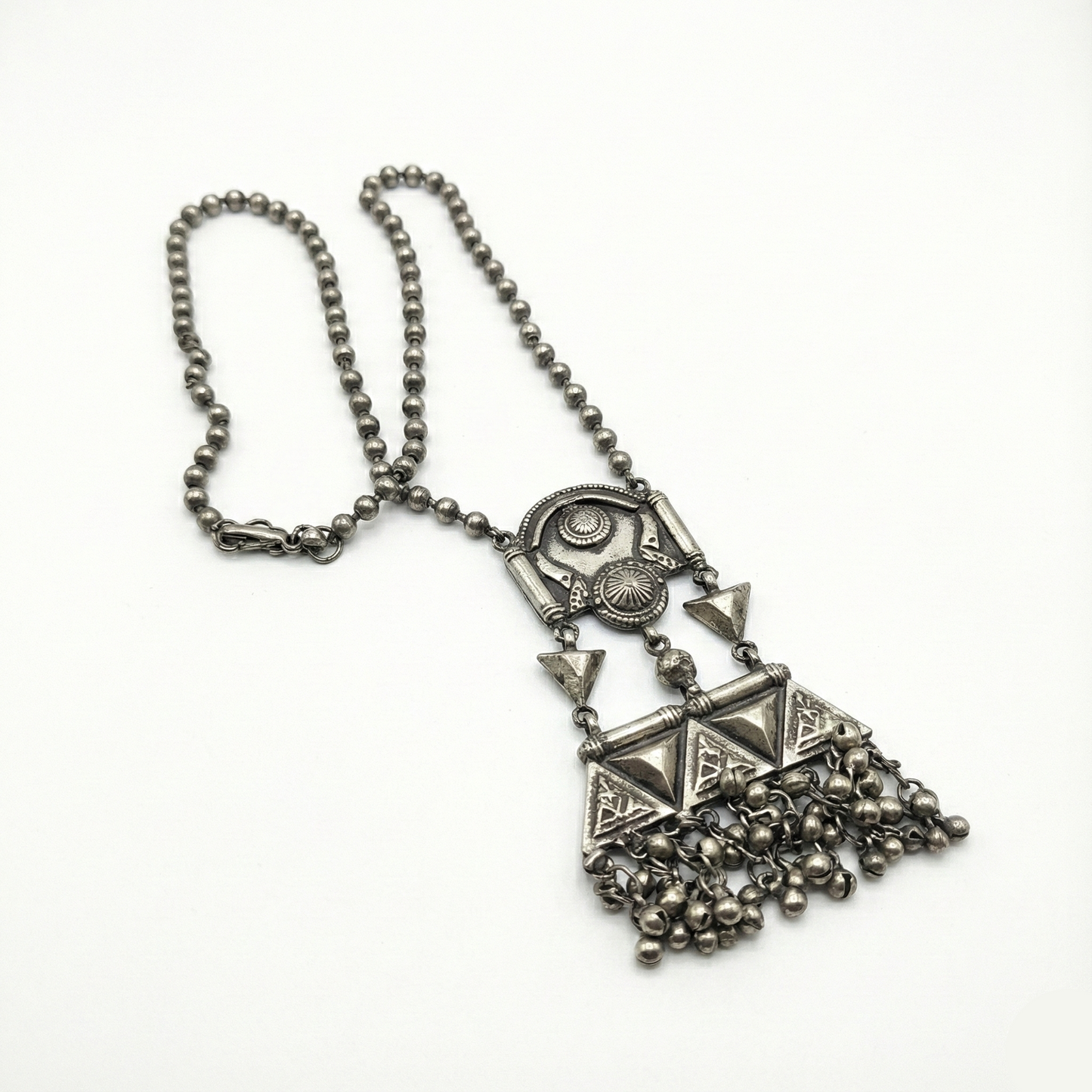 Silver necklace with geometric pendant and chain on a white background