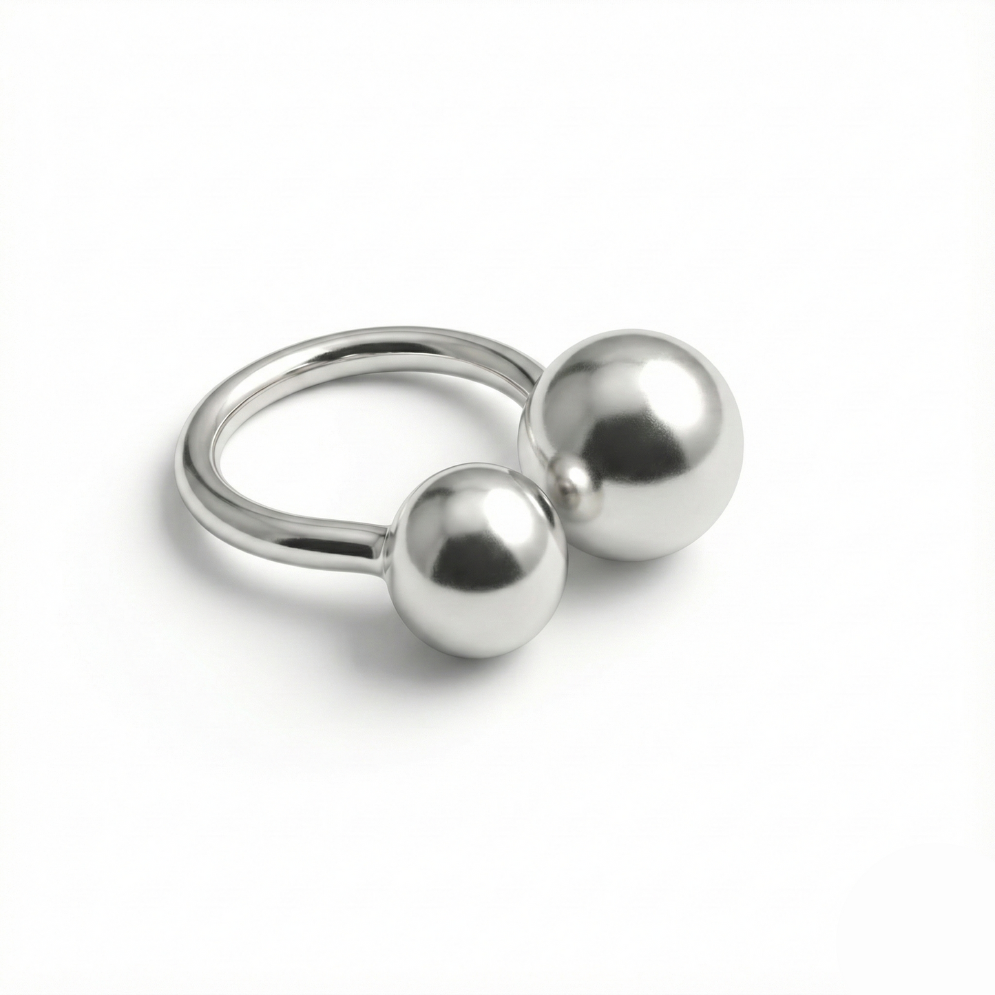 Silver ring with two spherical beads on a white background