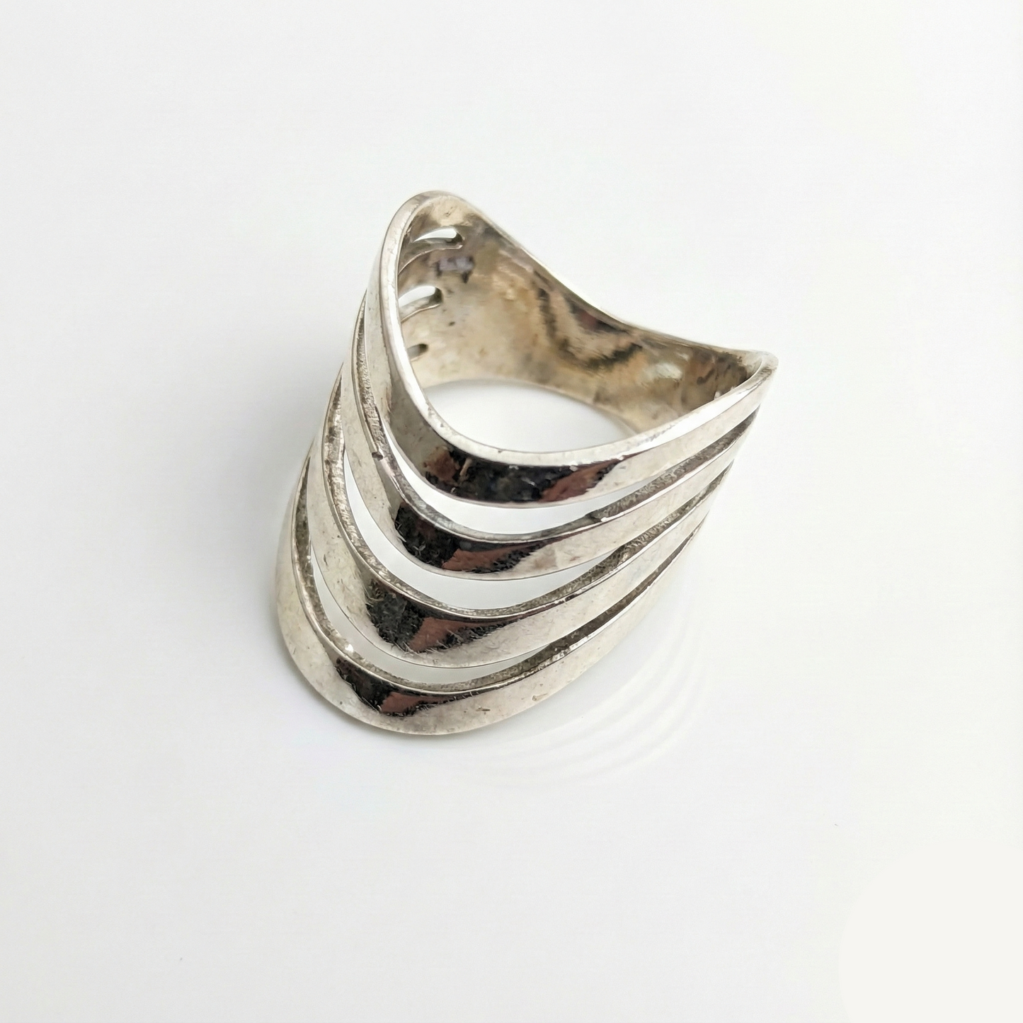 Silver ring with wavy design on a white background