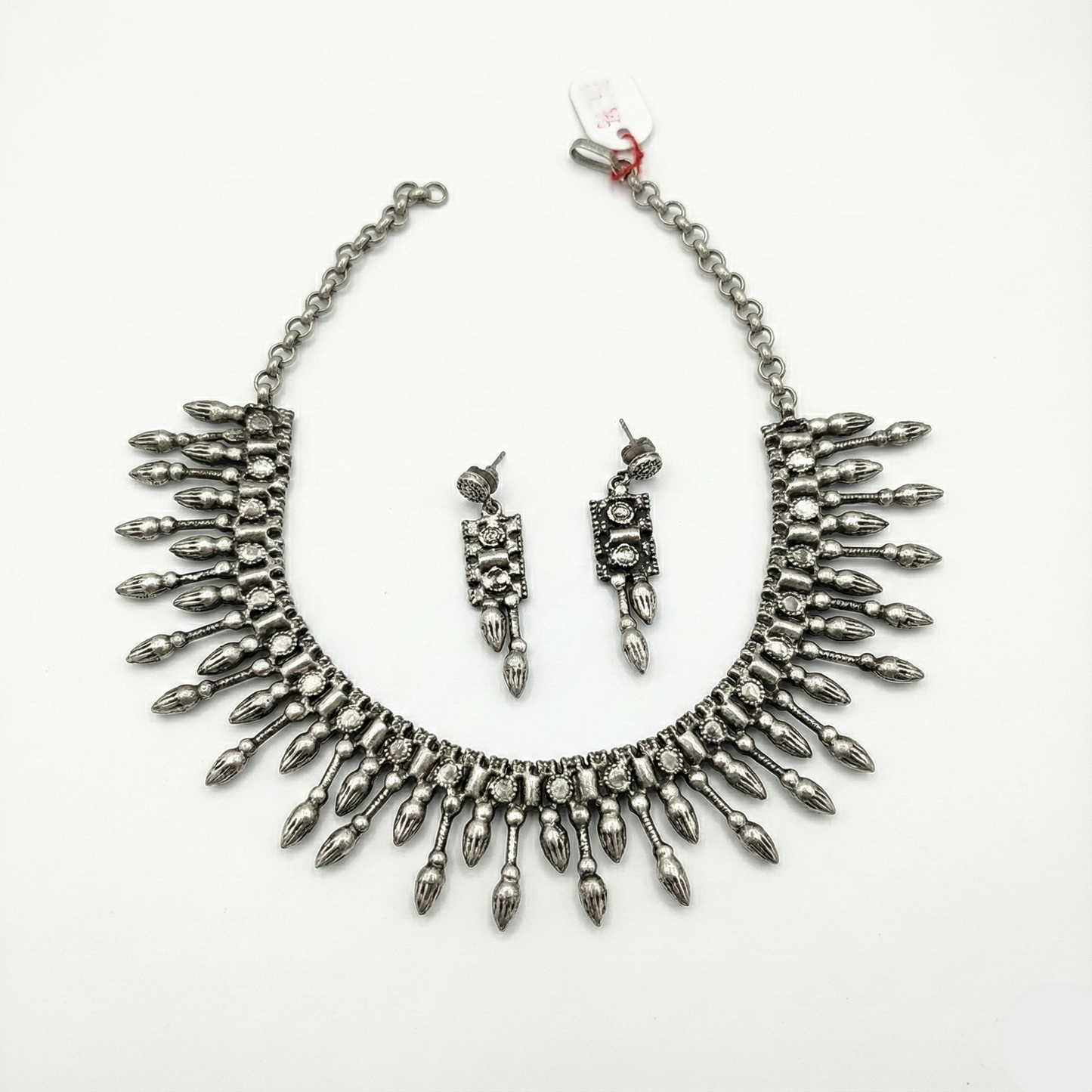Silver necklace and earrings set on a white background