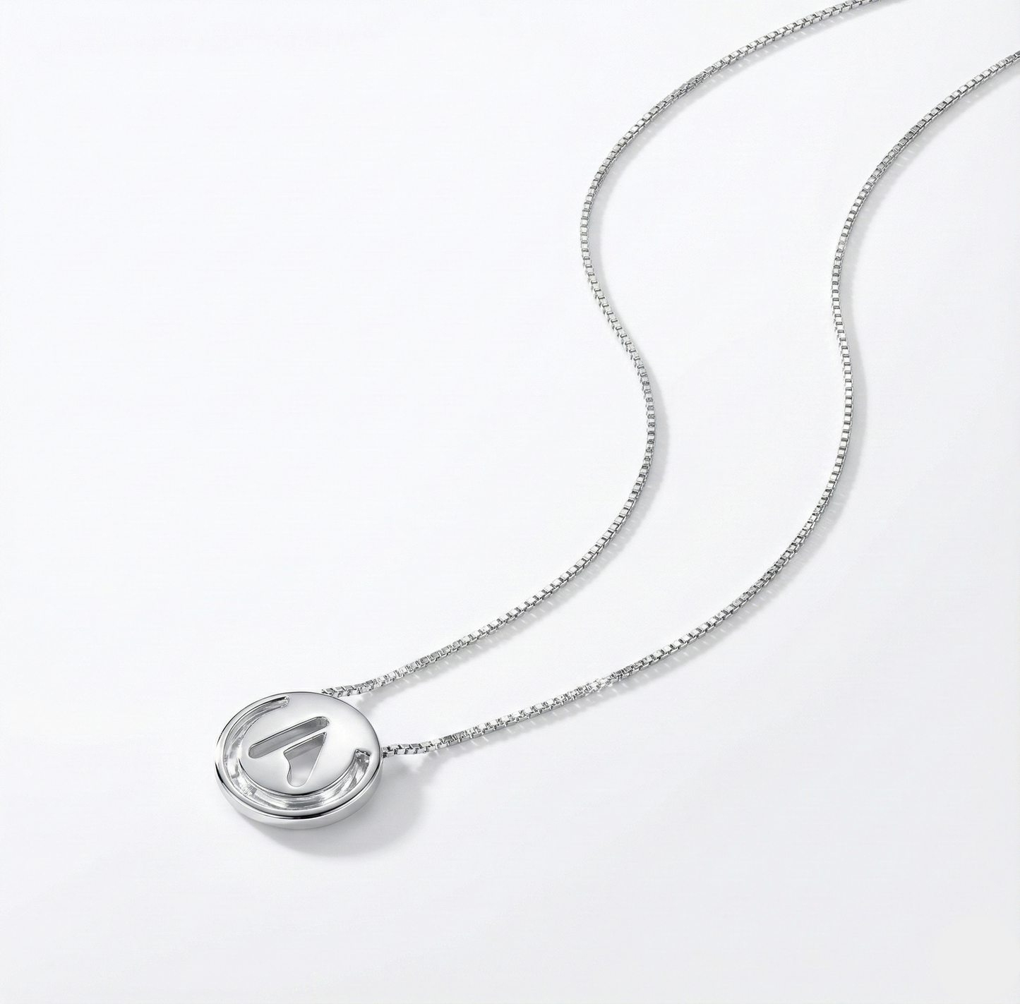 Silver necklace with a round pendant on a white background