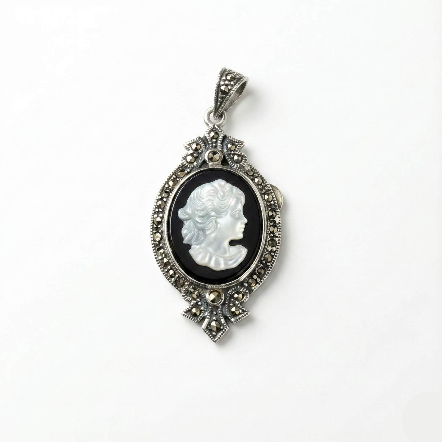 Cameo pendant with intricate silver frame on a white background