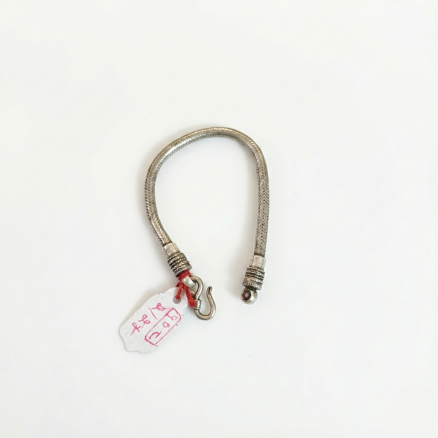 Silver bracelet with a tag on a white background