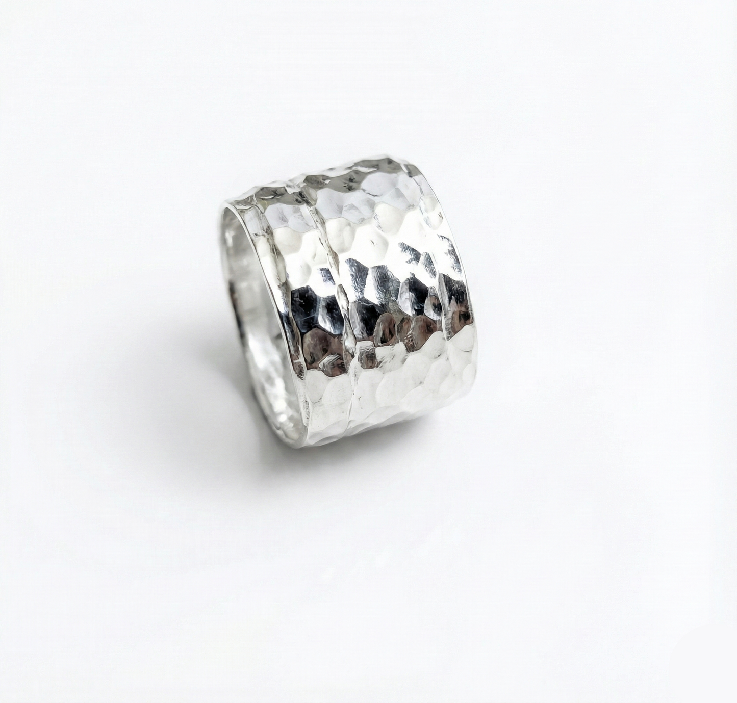 Silver ring with textured design on a white background