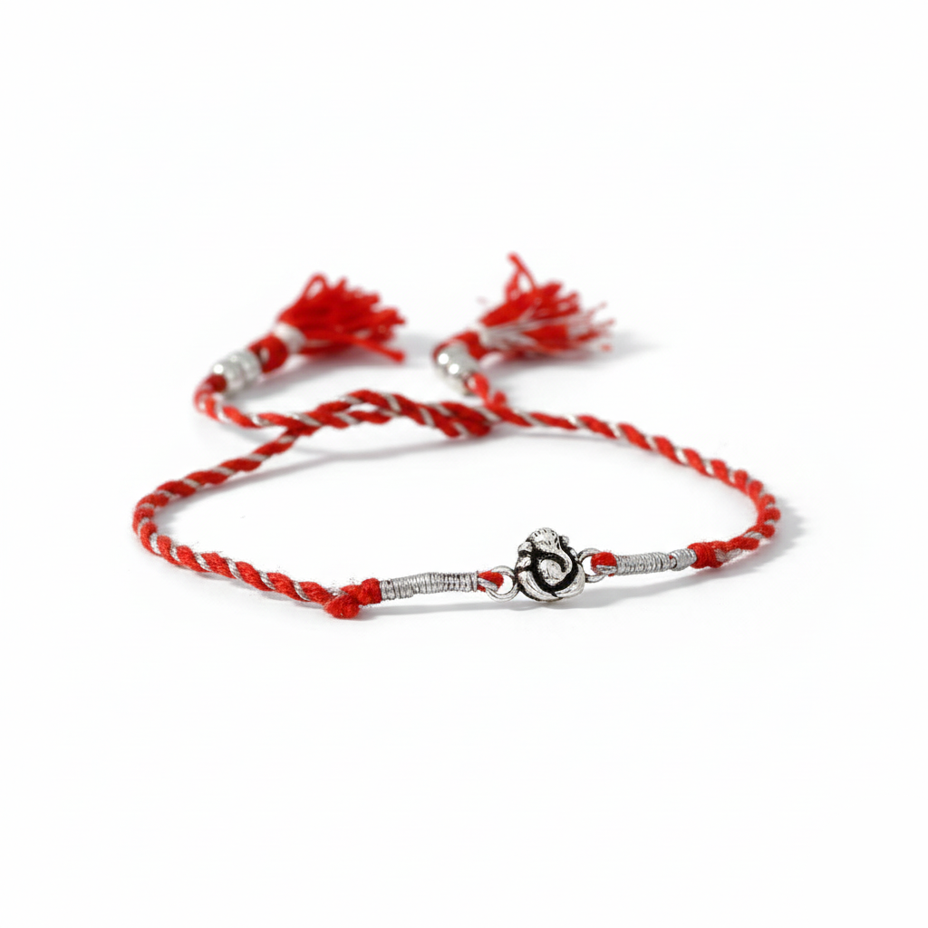Red and white braided bracelet with a silver charm on a white background
