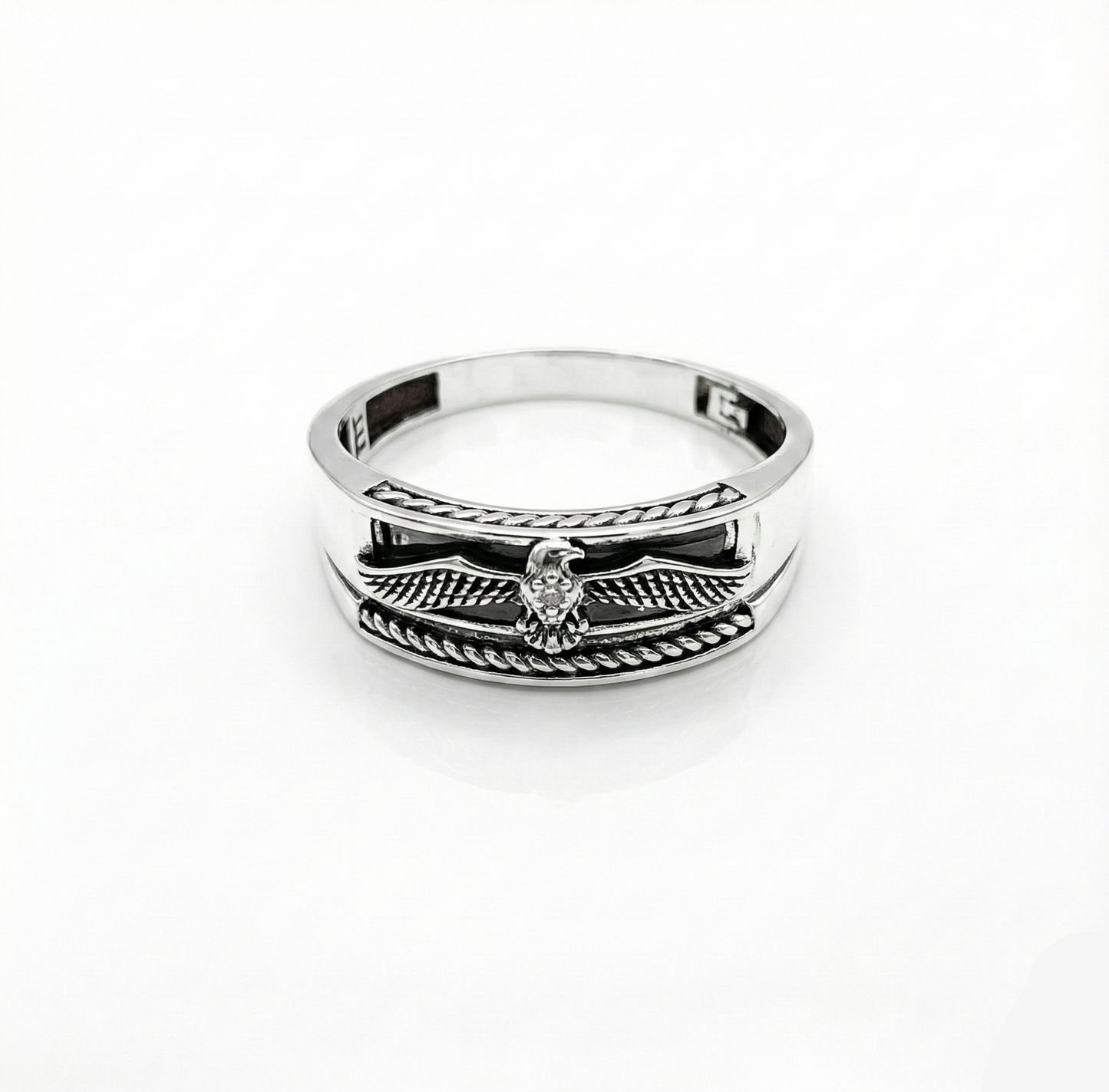 Silver ring with wing design on a white background