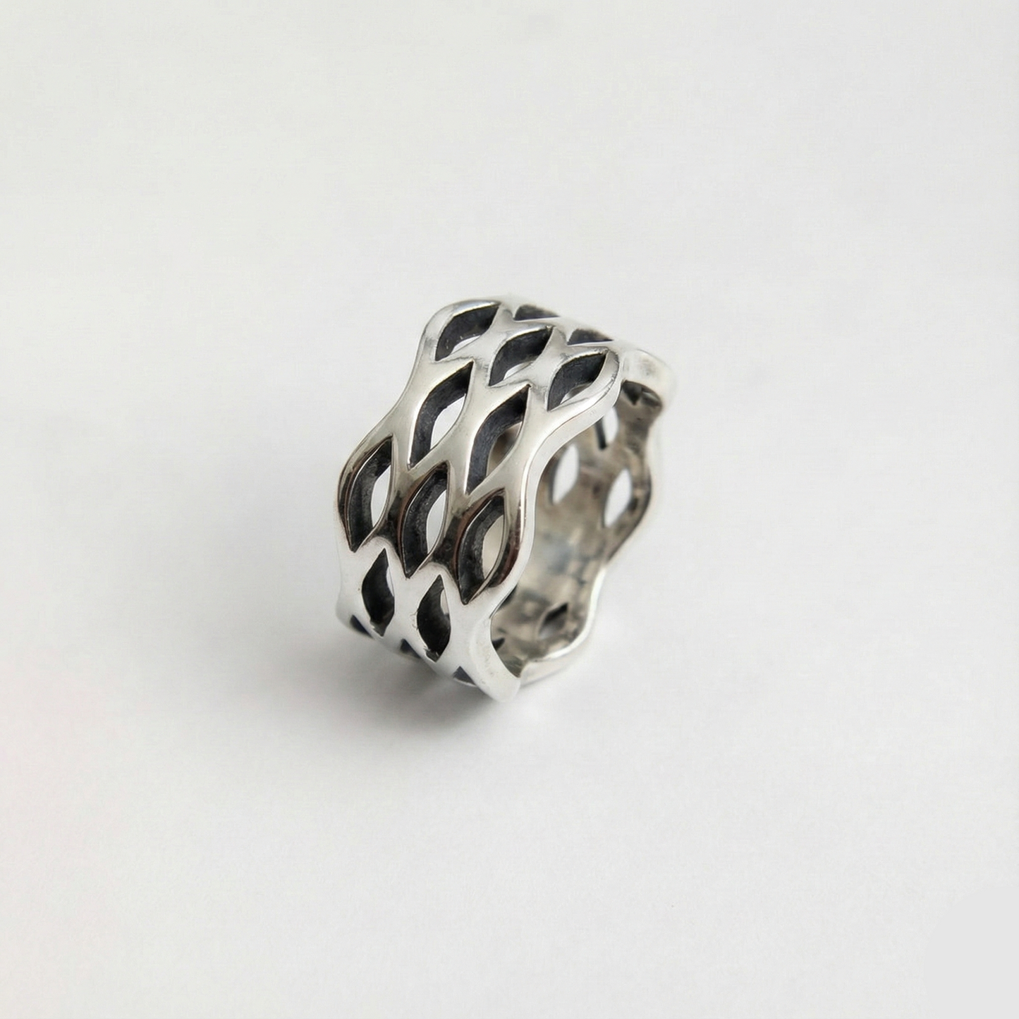 Silver ring with a wavy design on a white background
