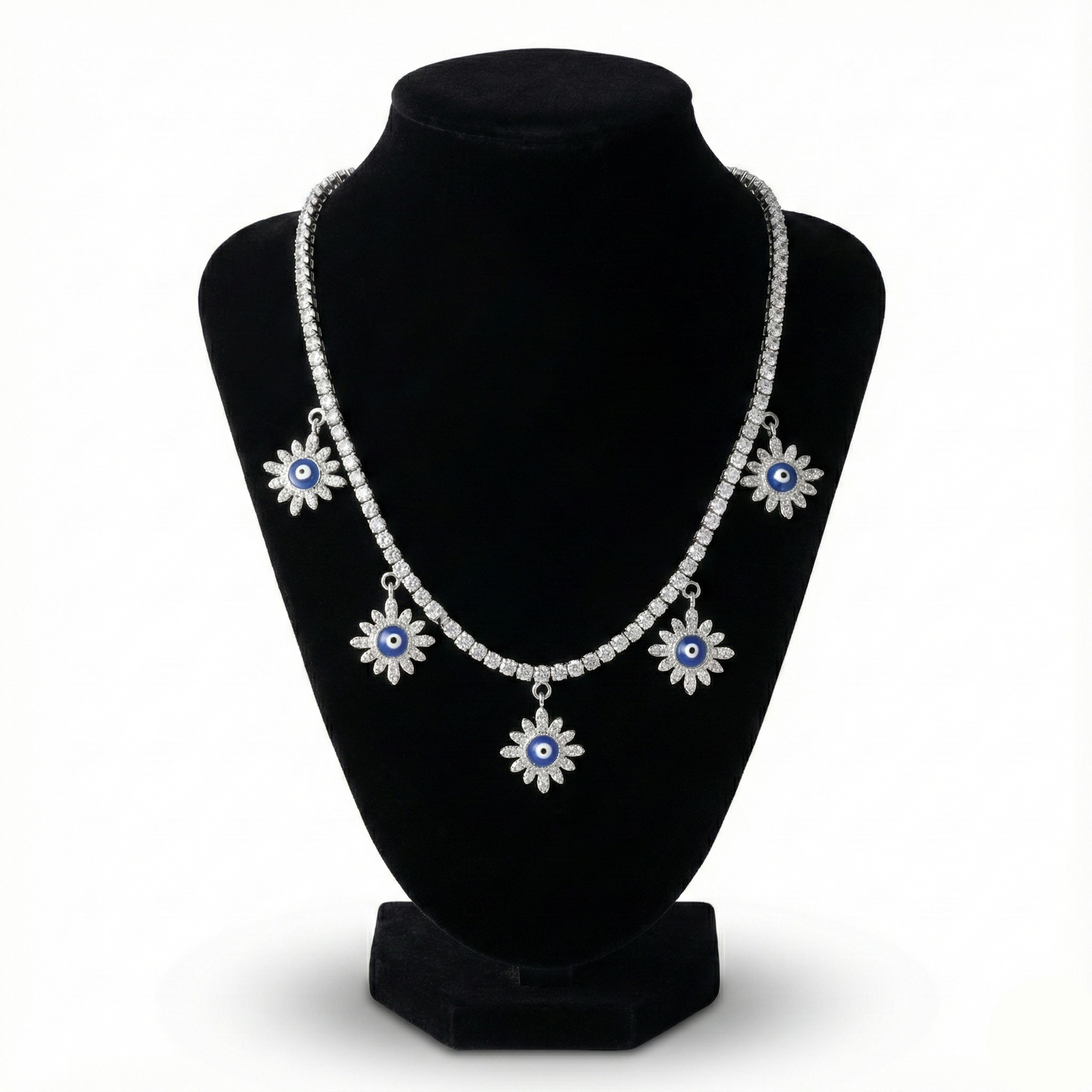 Necklace with floral designs on a black stand against a white background