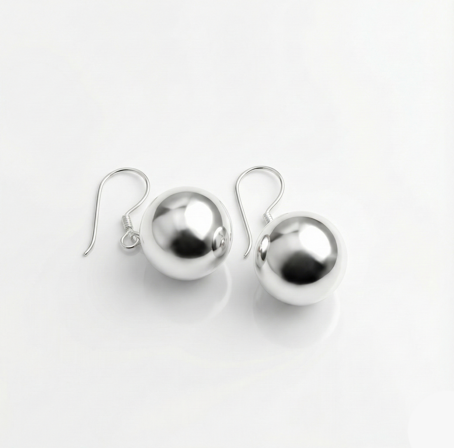 Pair of silver sphere earrings on a white background