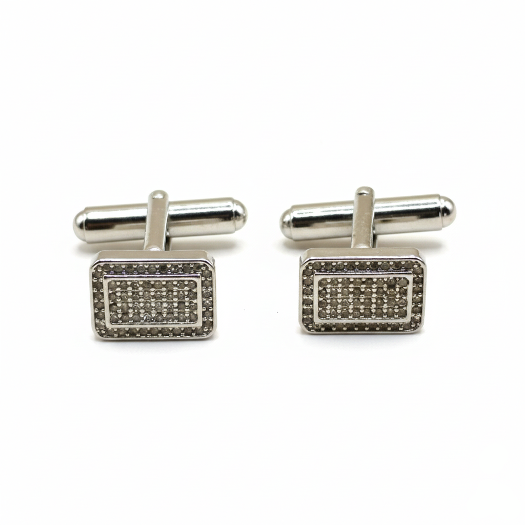Pair of silver rectangular cufflinks with gemstone accents on a white background