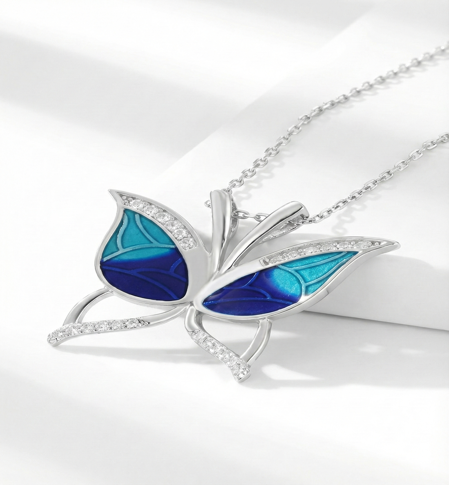 Butterfly-shaped pendant with blue wings on a white background