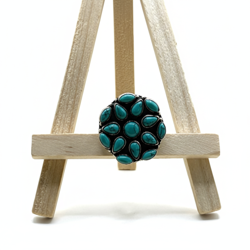 Turquoise ring on a small wooden easel against a white background