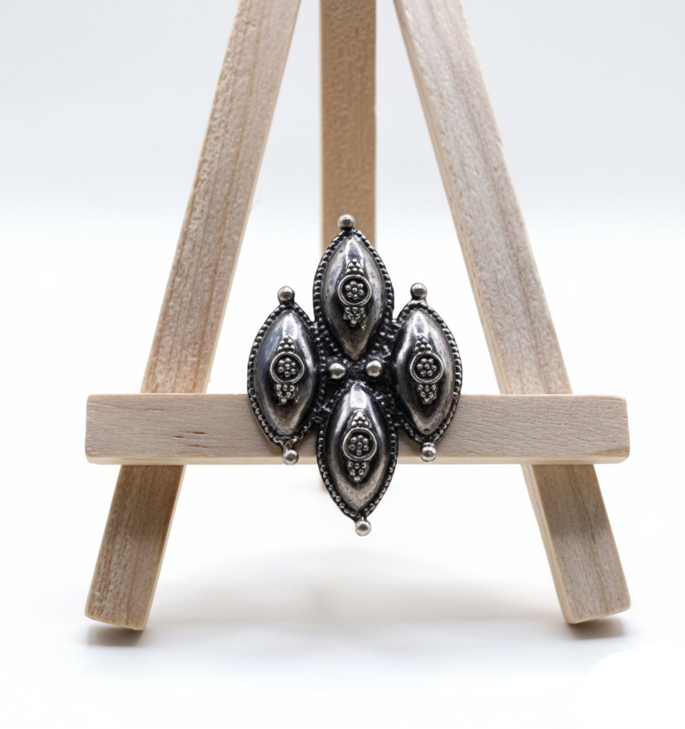 Pair of silver earrings on a small wooden easel against a white background
