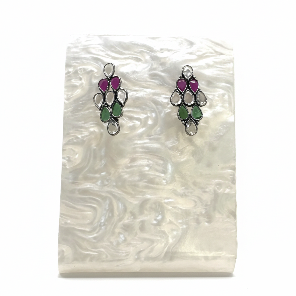 Pair of earrings with gemstones on a white shell background