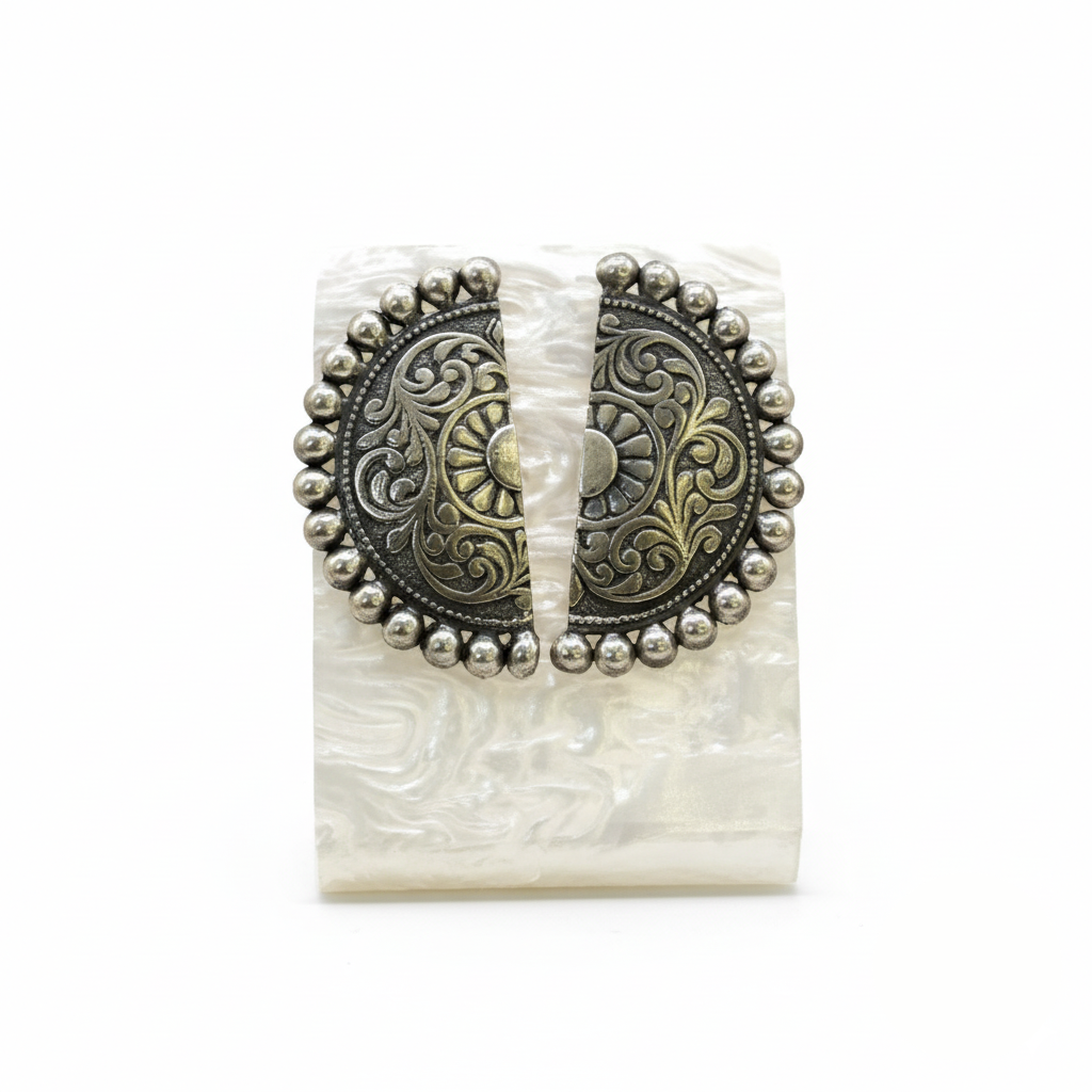 Decorative belt buckle with intricate patterns on a white background