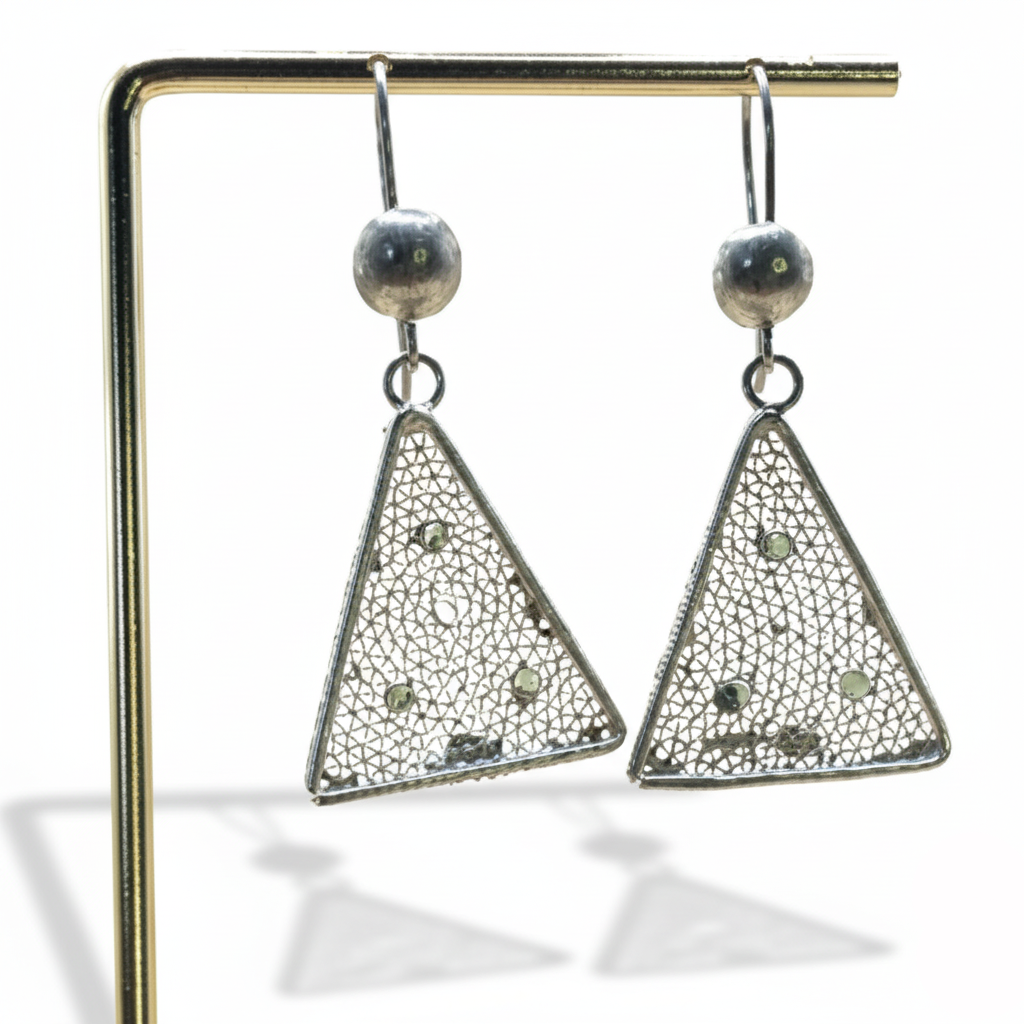 Triangular earrings on a stand with a white background