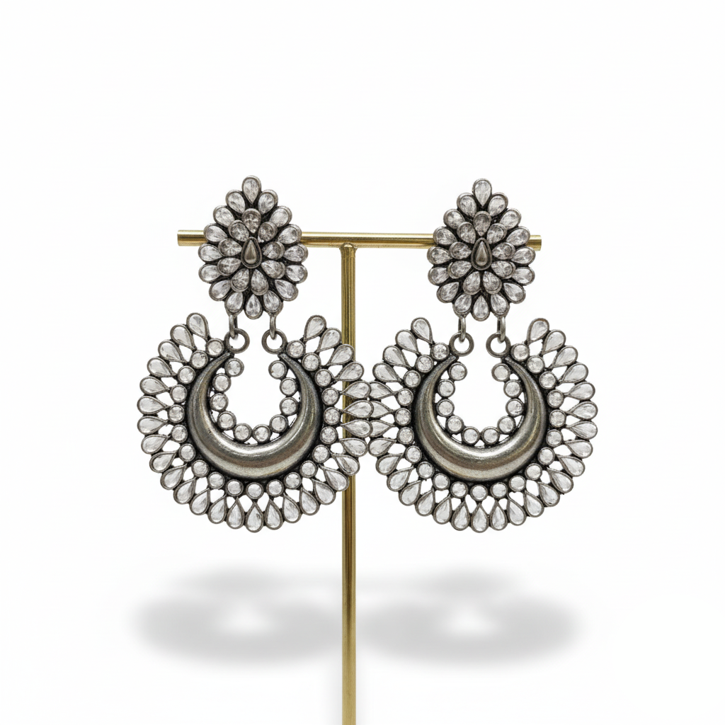 Pair of silver hoop earrings on a gold stand against a white background