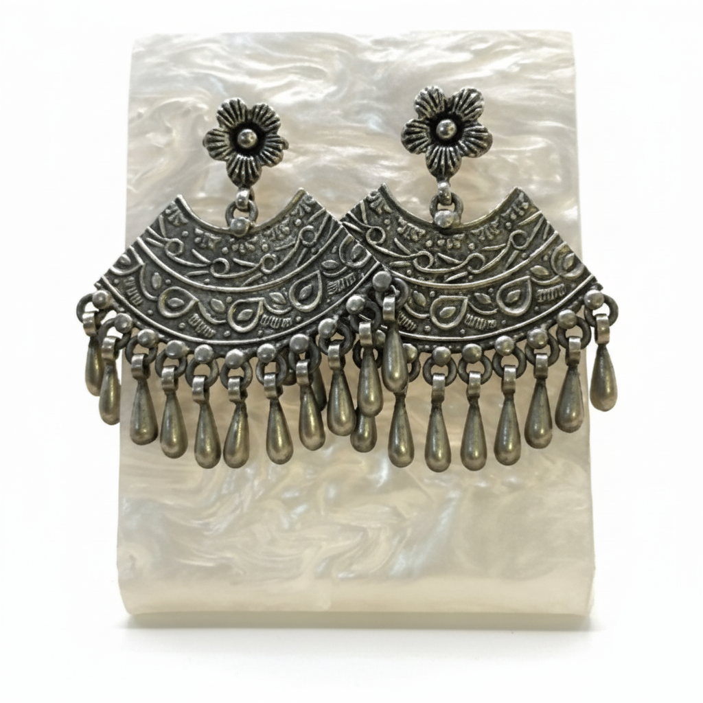 Pair of silver earrings with intricate designs on a white background