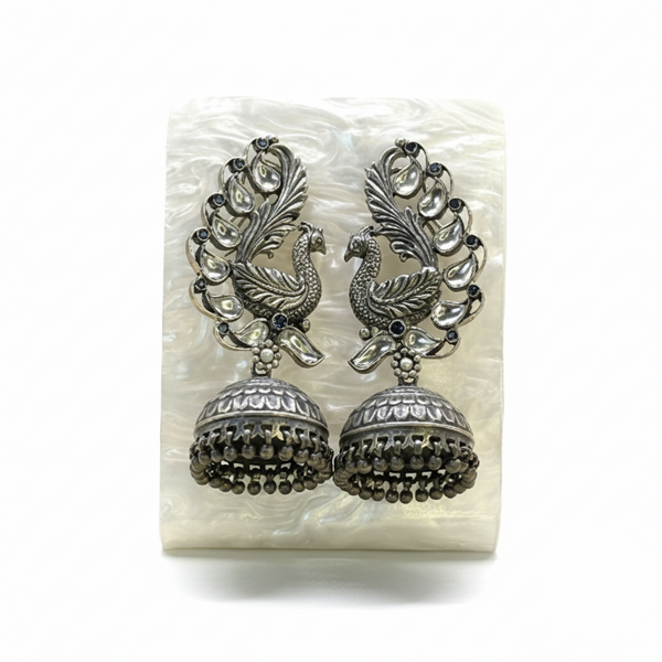 Pair of silver peacock feather earrings on a white background