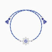 Necklace with a blue cord and a white evil eye pendant on a light gray background