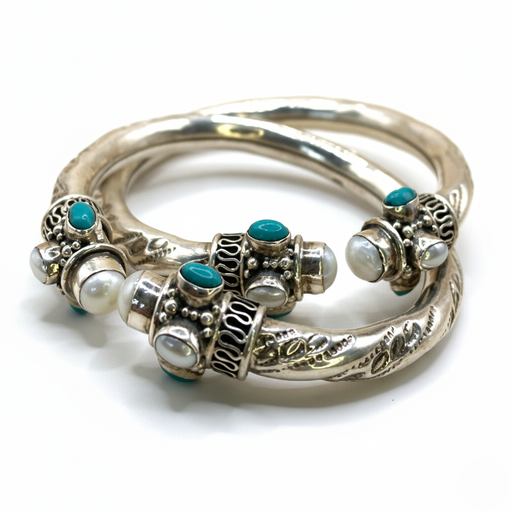 Silver bangles with turquoise and pearl-like stones on a white background