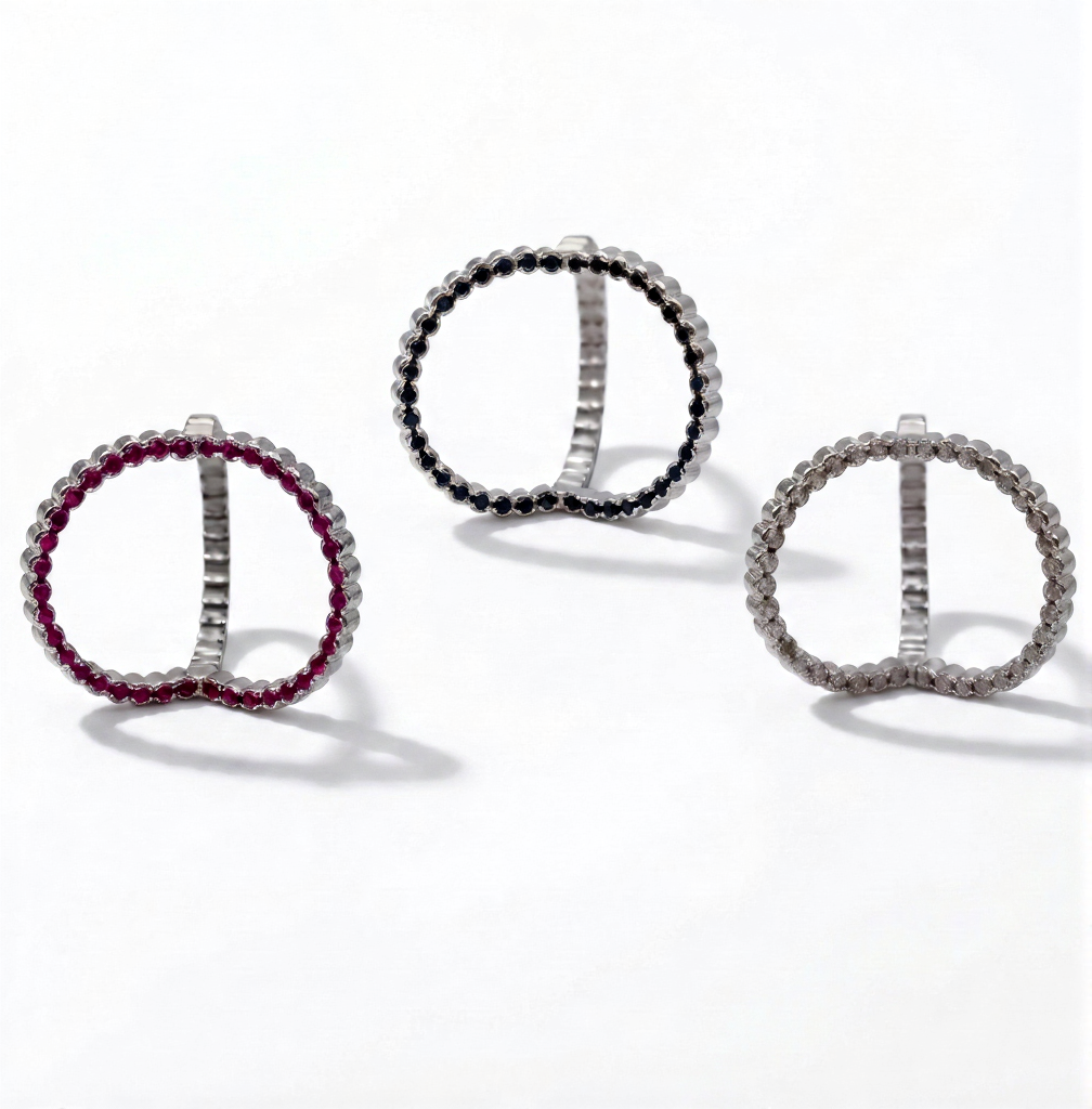 Three circular earrings with different gemstone colors on a white background