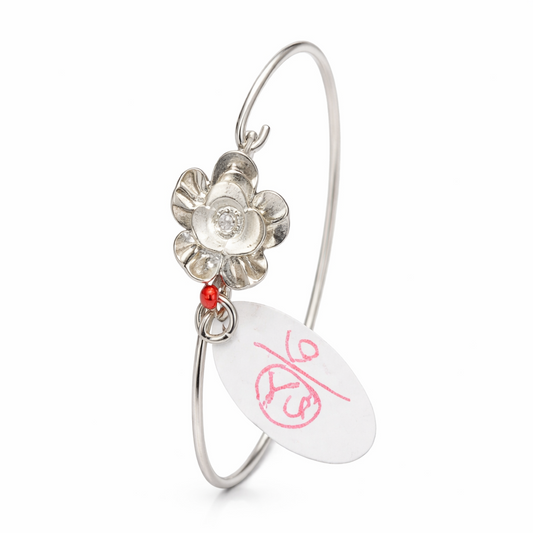 Silver bracelet with a floral design and red accent on a white background