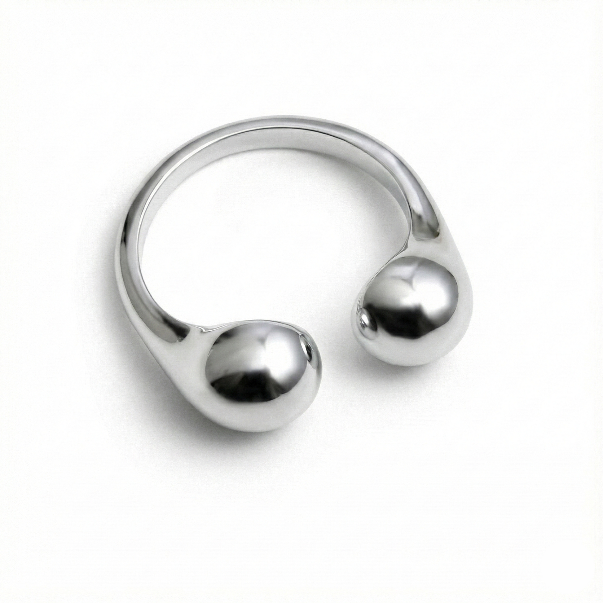 Silver ring with spherical ends on a white background