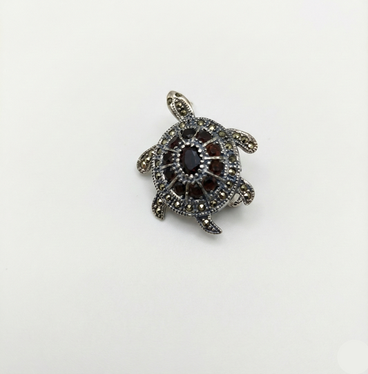 Tortoiseshell pendant with marcasite stones on a white background