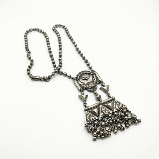 Silver necklace with geometric pendant and chain on a white background