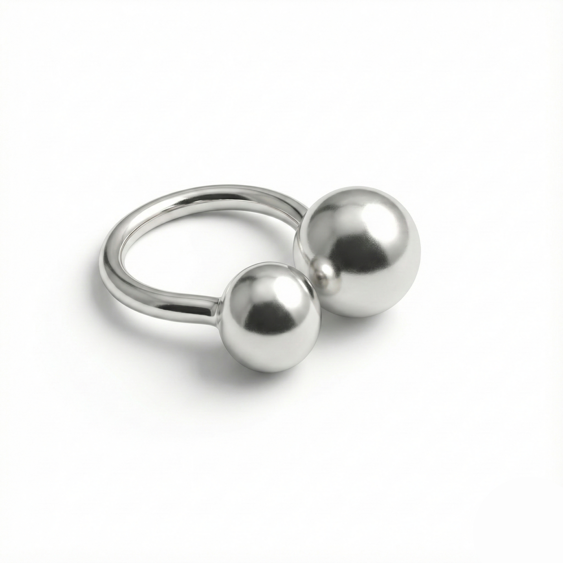 Silver ring with two spherical beads on a white background
