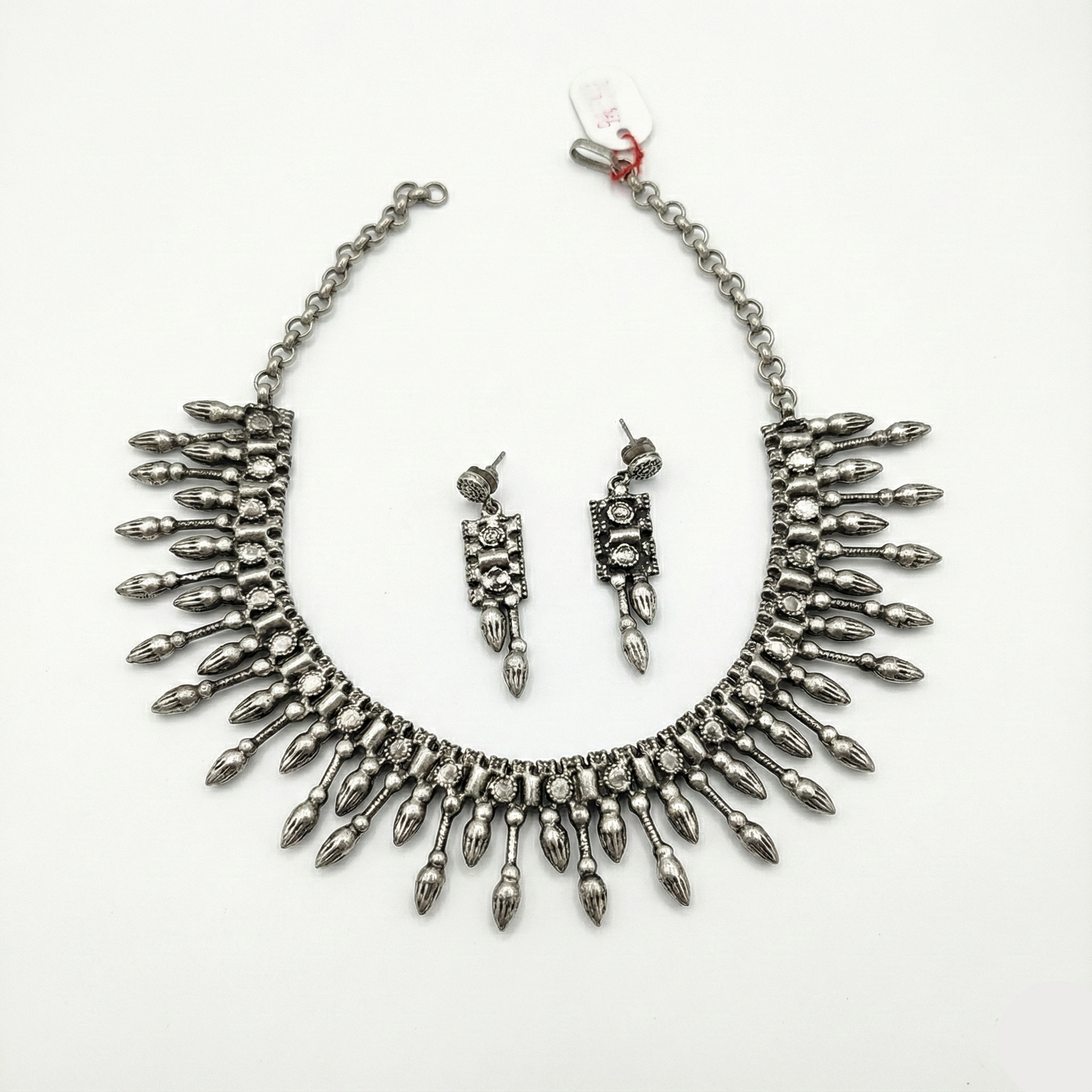 Silver necklace and earrings set on a white background