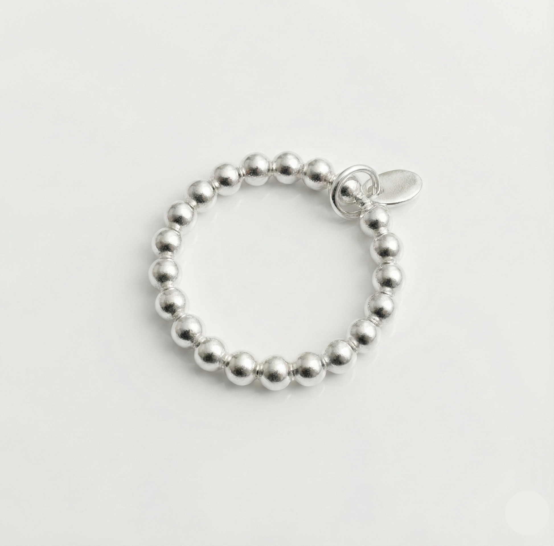 Silver beaded bracelet on a light gray background