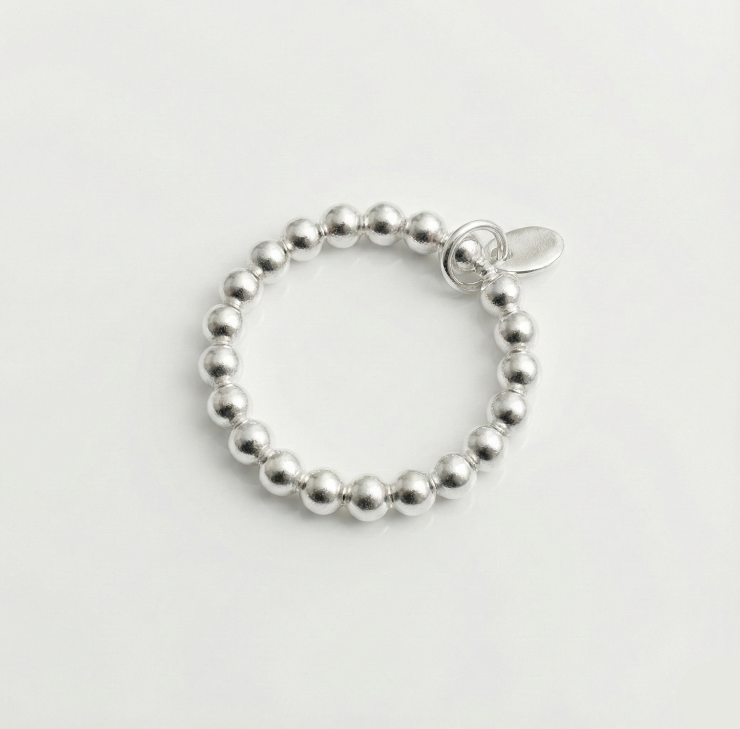 Silver beaded bracelet on a light gray background