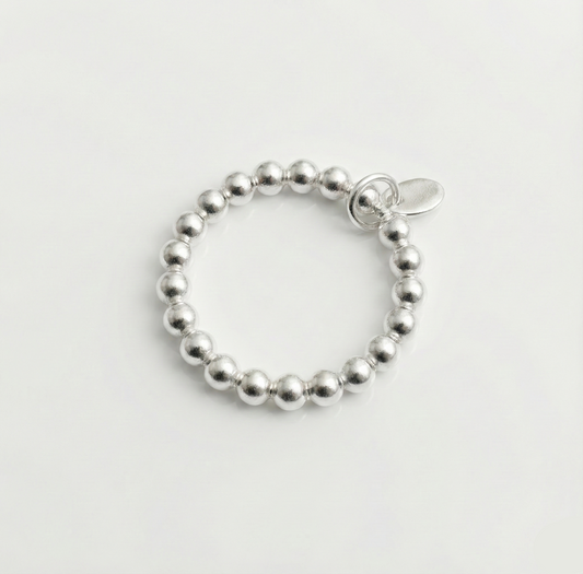 Silver beaded bracelet on a light gray background
