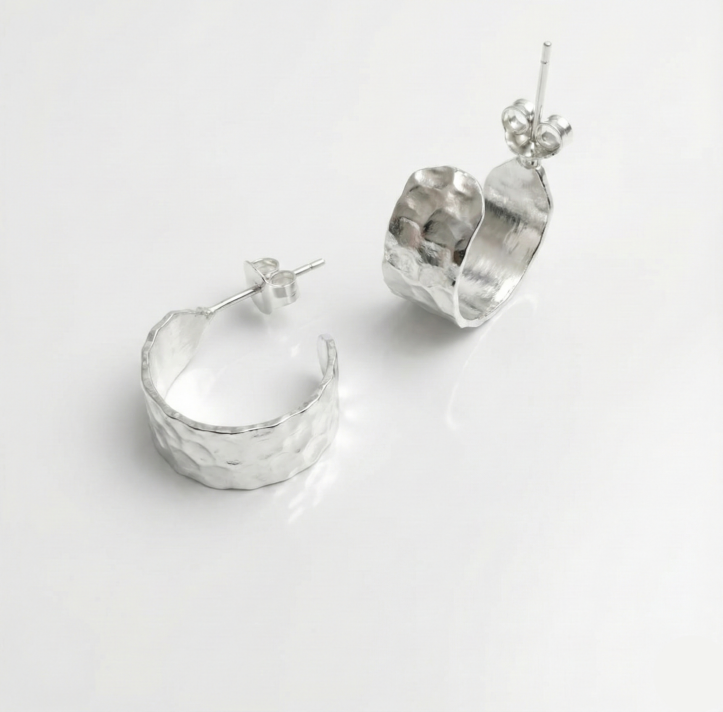 Pair of silver hoop earrings on a light gray background