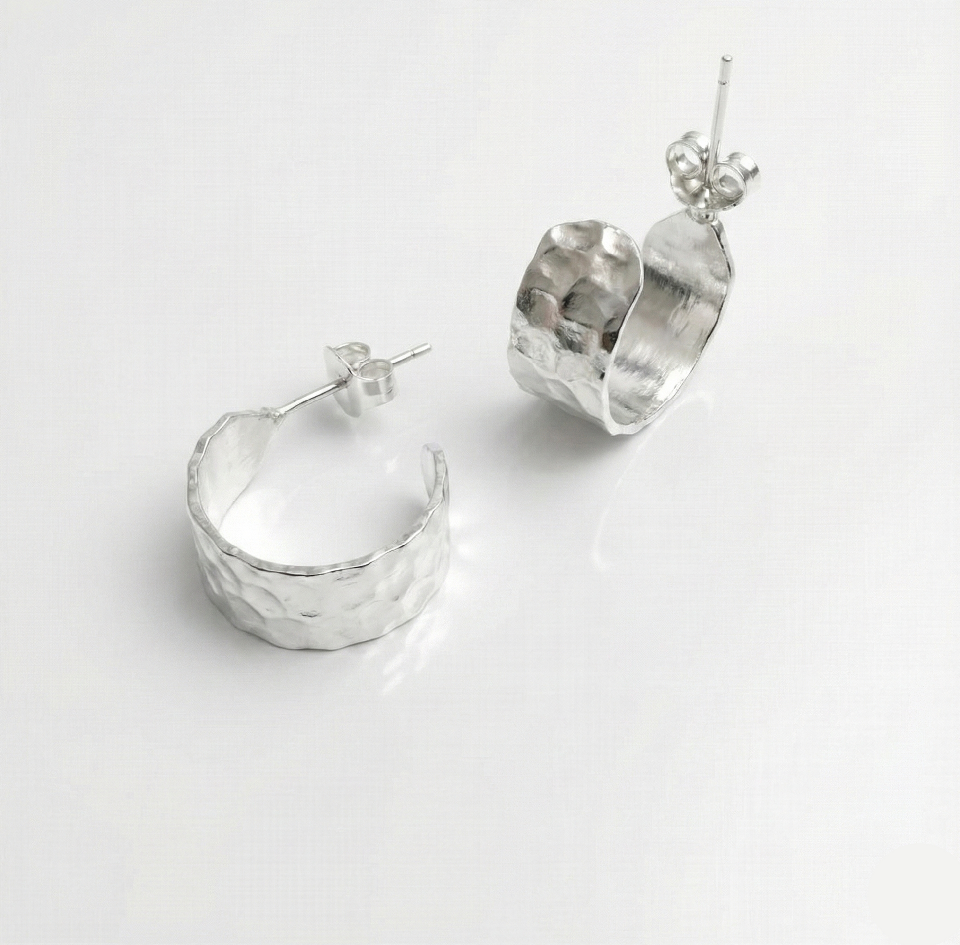 Pair of silver hoop earrings on a light gray background