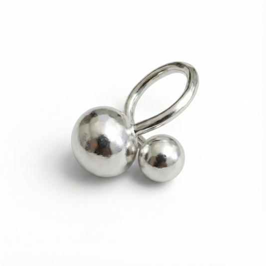 Silver earring with two spherical beads on a white background