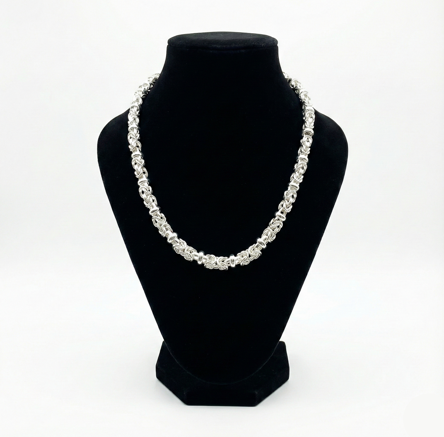 Pearl necklace on a black bust against a white background