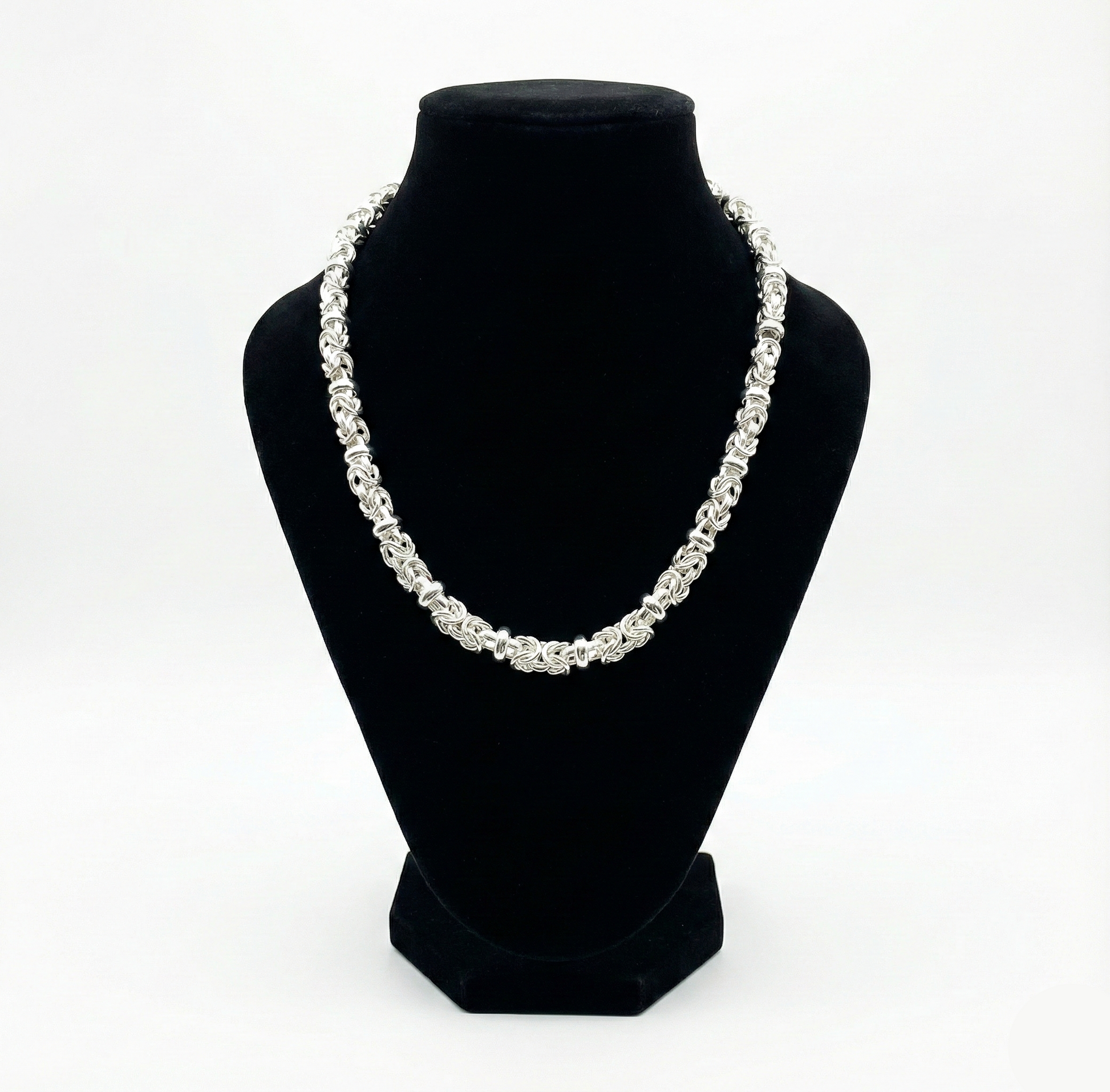 Pearl necklace on a black bust against a white background