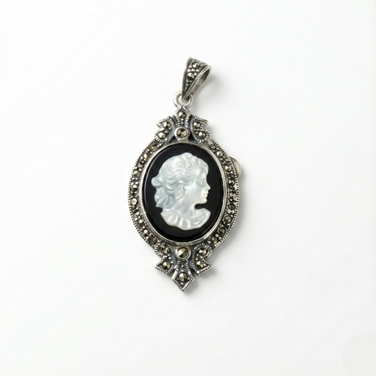 Cameo pendant with intricate silver frame on a white background