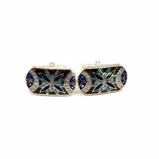 Pair of cufflinks with decorative design on a white background