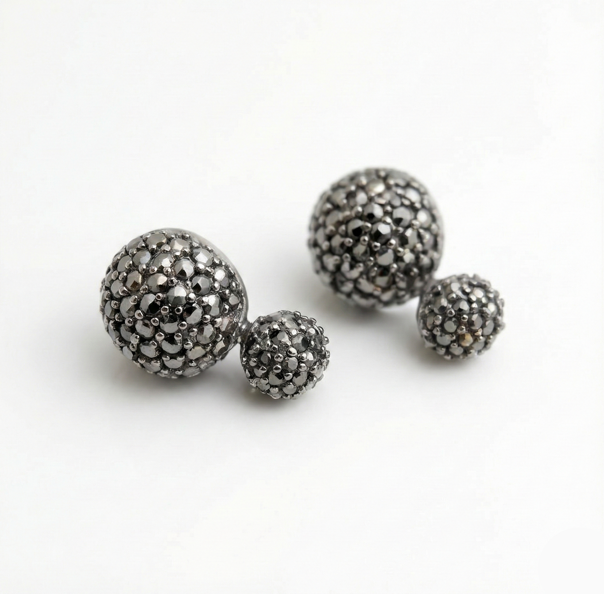 Pair of silver spherical earrings on a white background