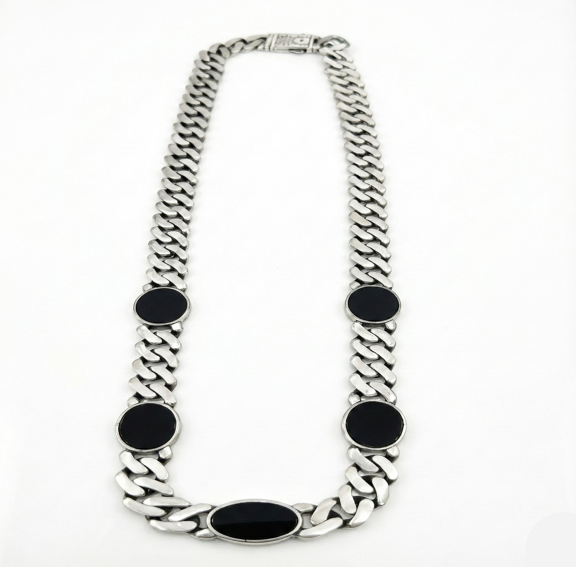 Silver chain necklace with black oval pendants on a white background