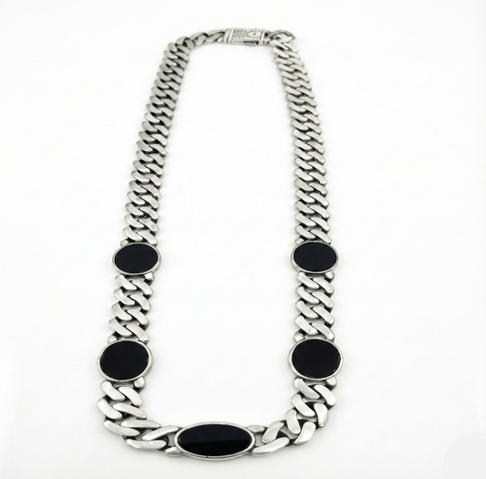 Silver chain necklace with black oval pendants on a white background