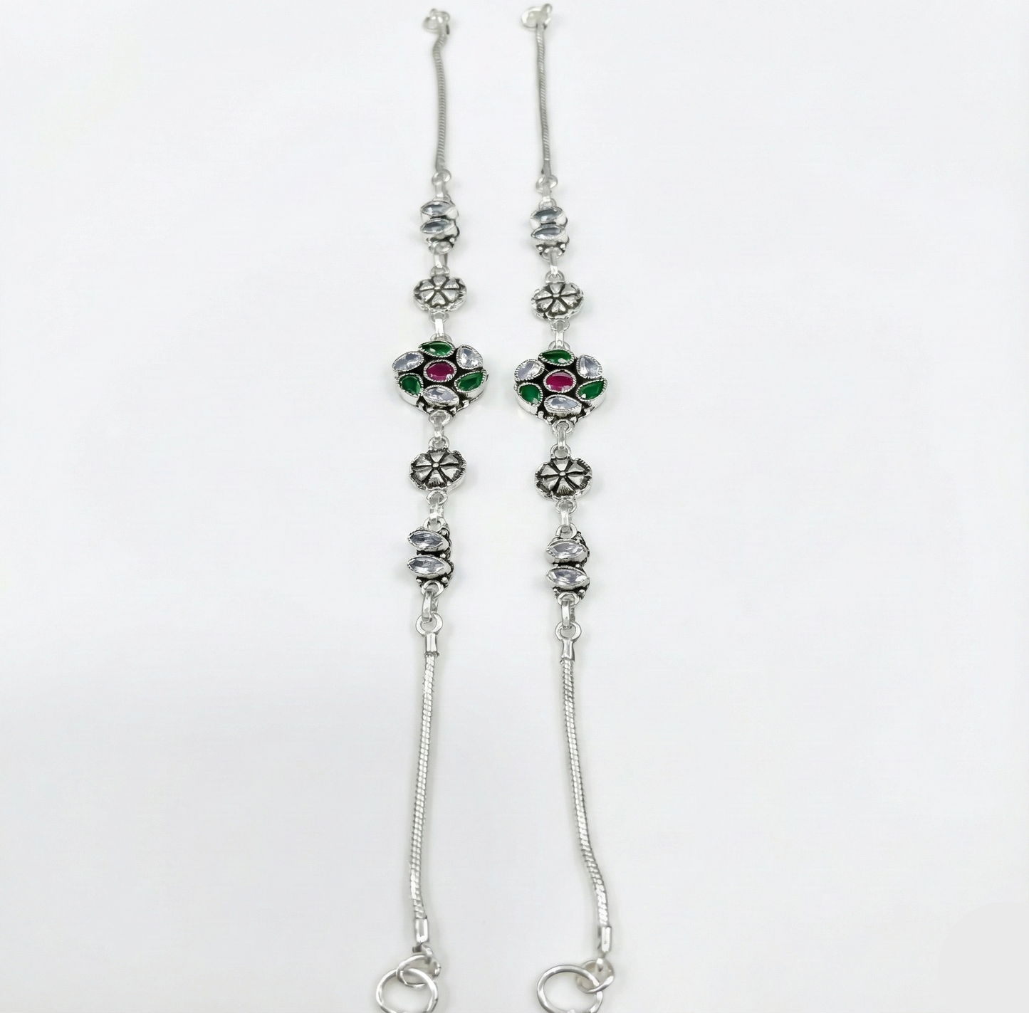 Silver floral anklets with gemstones on a white background