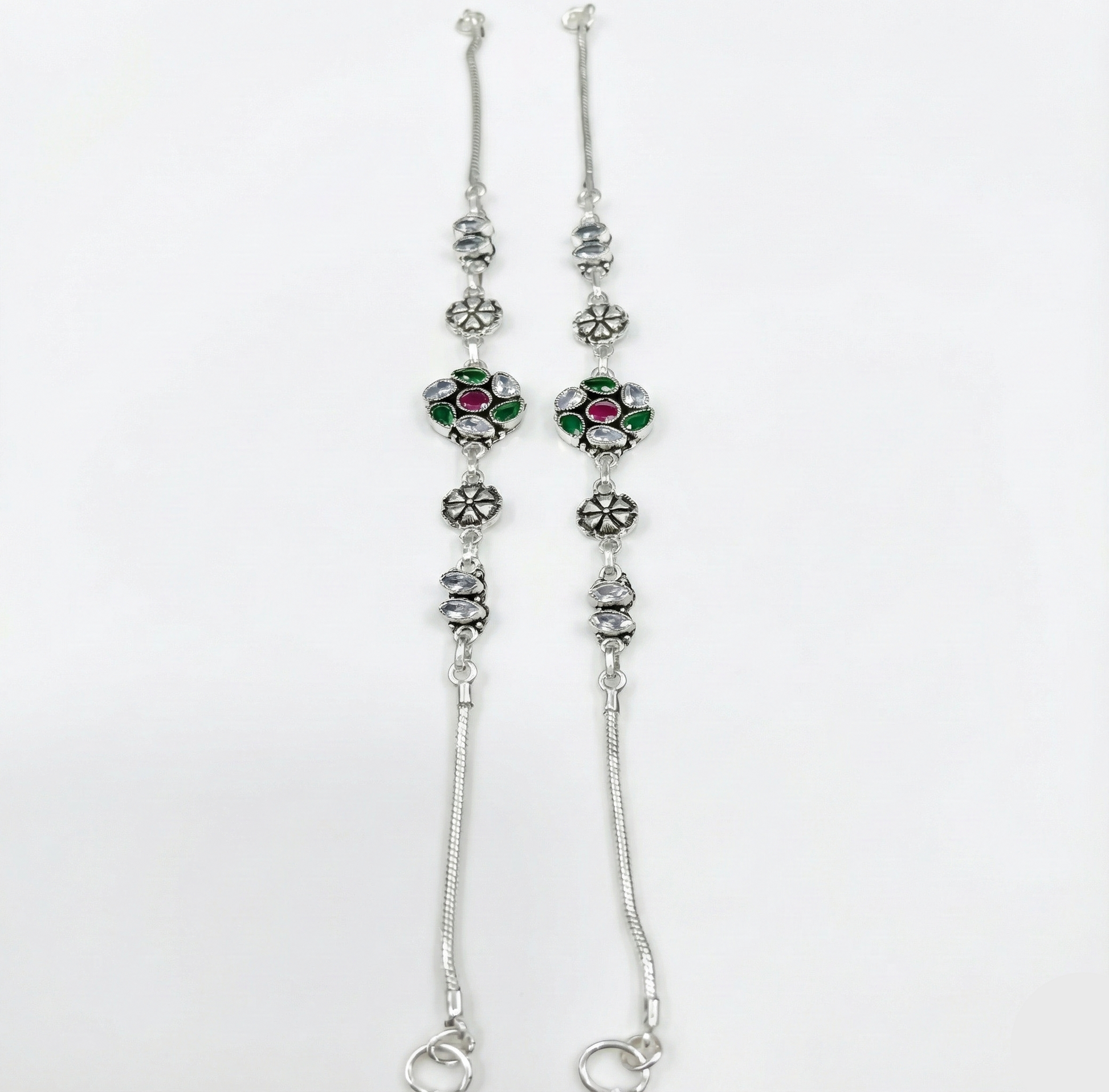 Silver floral anklets with gemstones on a white background