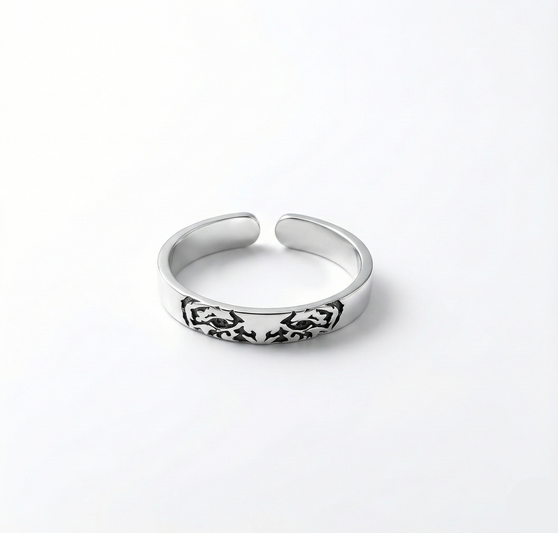 Silver ring with intricate design on a white background