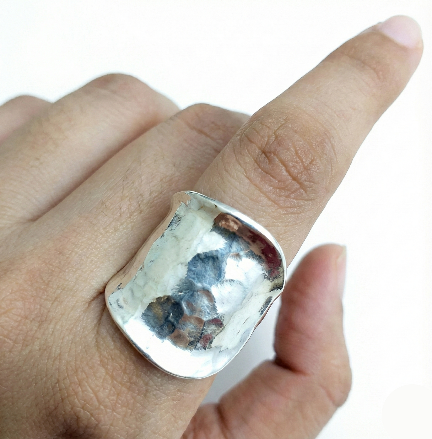 Silver ring on a finger with a white background
